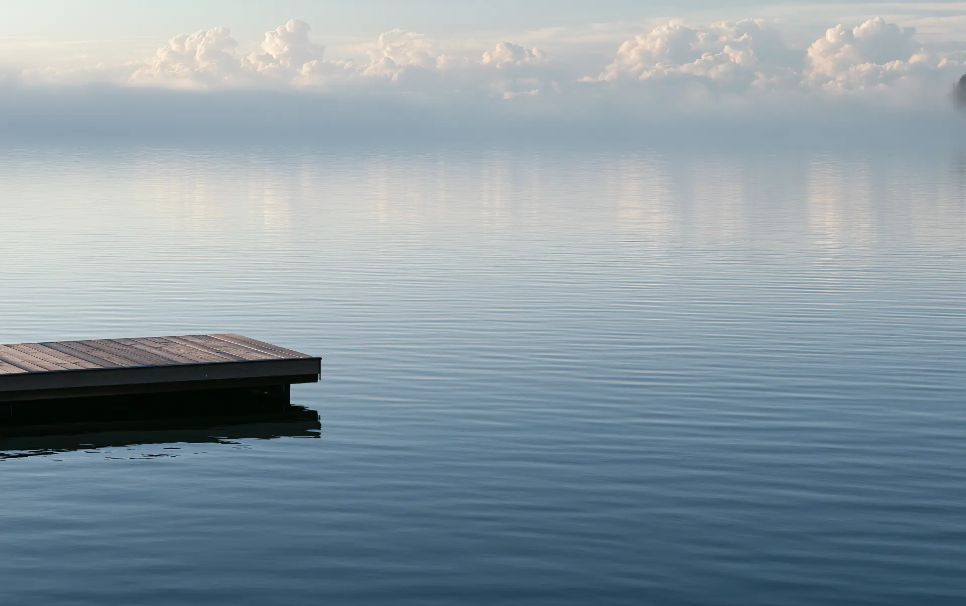 Ruhiger Steg an einem stillen See im Morgenlicht
