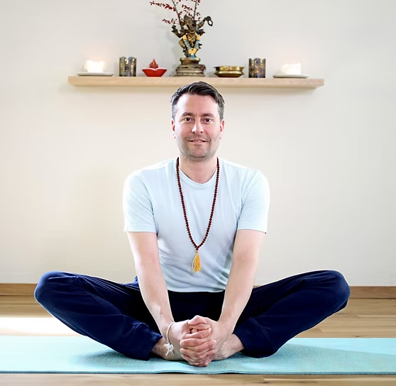 Michel sitzt meditierend im Yogaraum